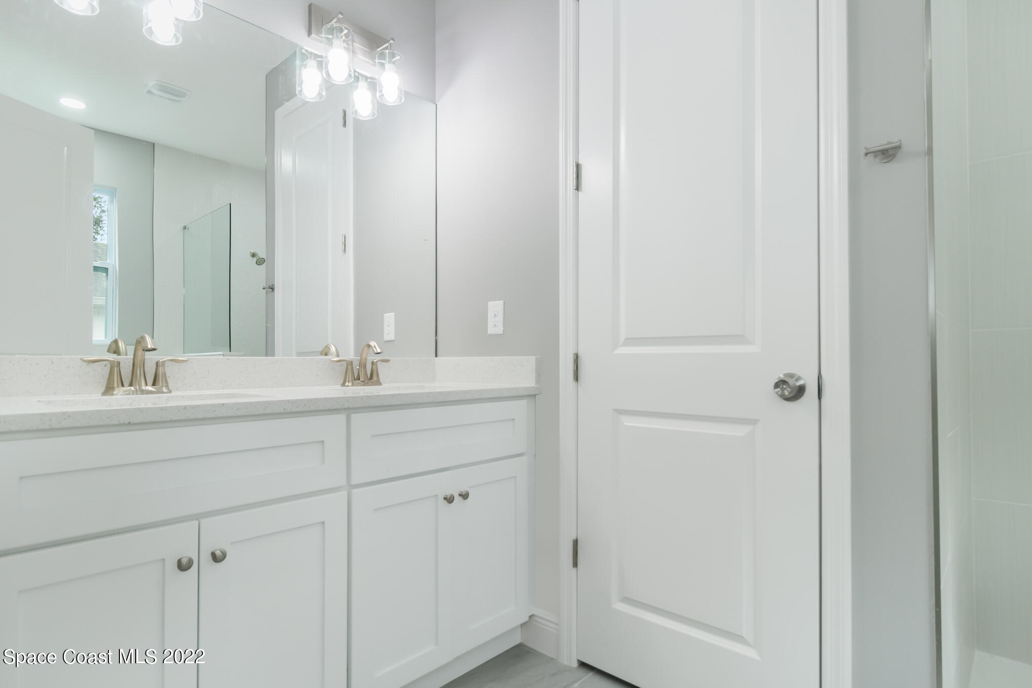 295 San Marino Road Southwest Palm Bay, FL 32908 - Photo 18 of 49 a bathroom with a double vanity sink and a mirror