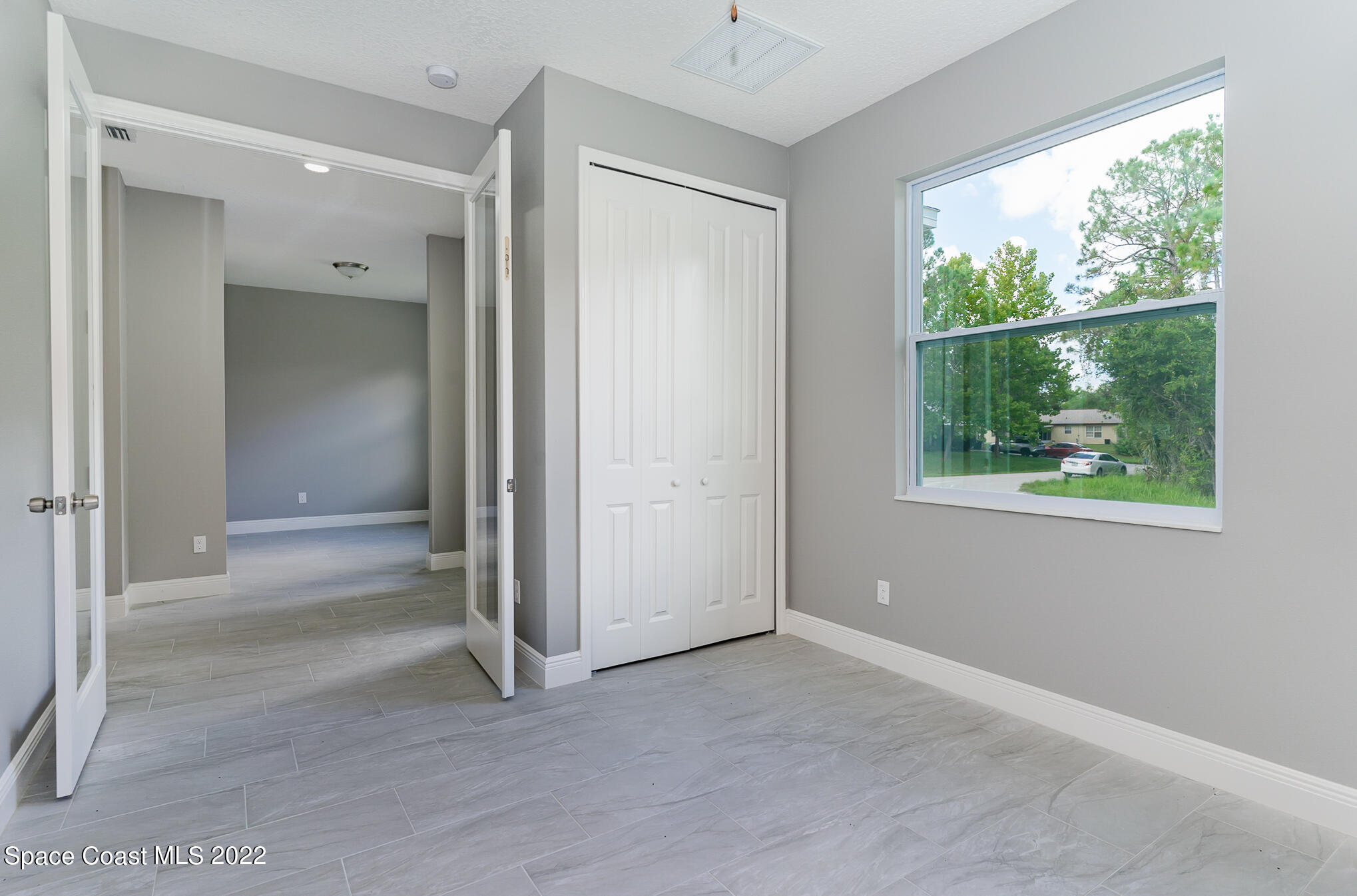 295 San Marino Road Southwest Palm Bay, FL 32908 - Photo 26 of 49 an empty room with windows and closet