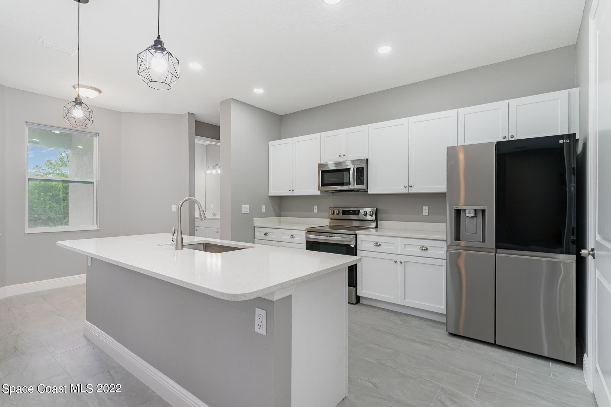 295 San Marino Road Southwest Palm Bay, FL 32908 - Photo 29 of 49 a kitchen with stainless steel appliances a refrigerator sink and microwave