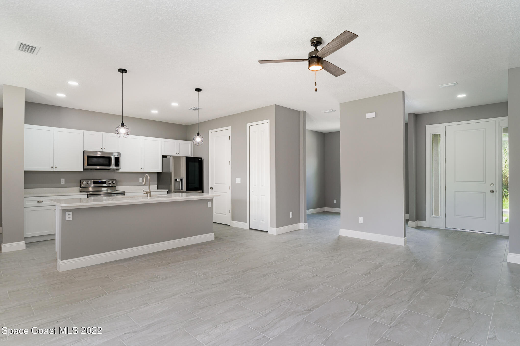 295 San Marino Road Southwest Palm Bay, FL 32908 - Photo 35 of 49 a view of an empty room with kitchen appliances and a ceiling fan