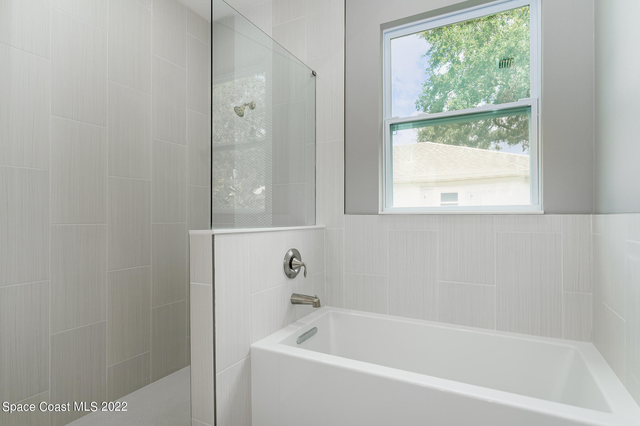 295 San Marino Road Southwest Palm Bay, FL 32908 - Photo 38 of 49 a white bath tub sitting next to a window