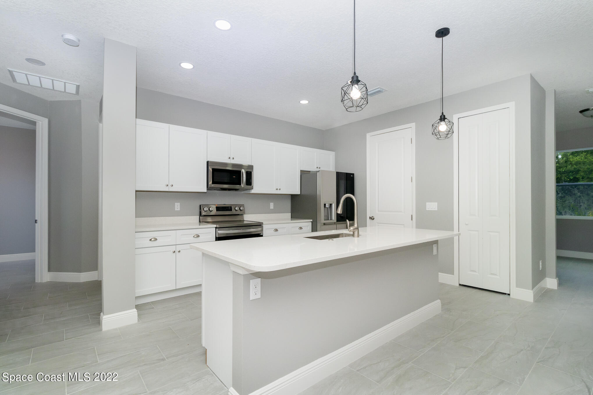 295 San Marino Road Southwest Palm Bay, FL 32908 - Photo 4 of 49 a kitchen with kitchen island a sink stainless steel appliances and cabinets