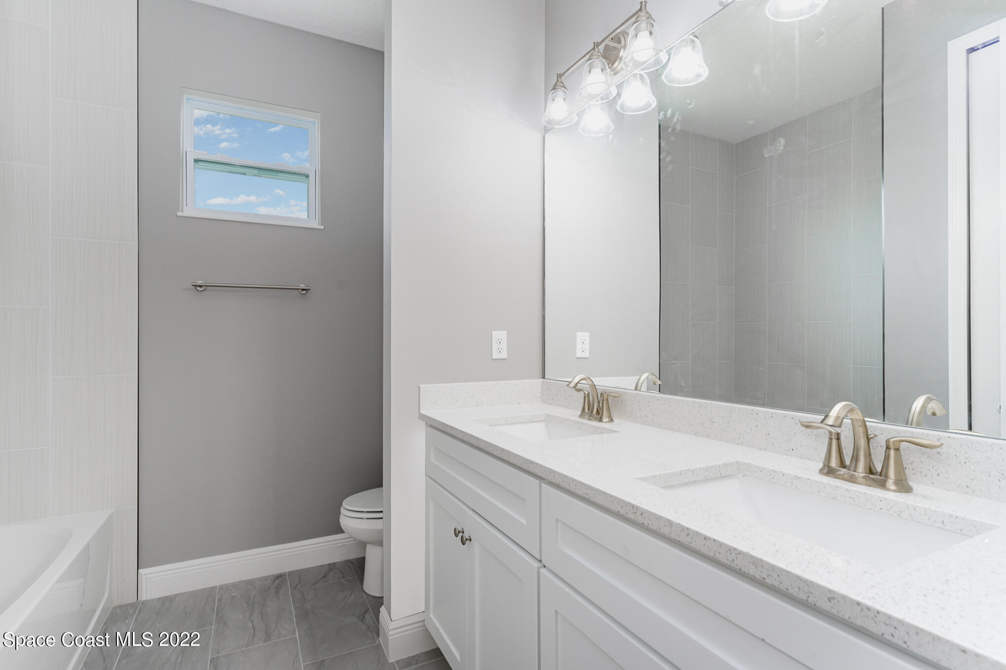 295 San Marino Road Southwest Palm Bay, FL 32908 - Photo 42 of 49 a bathroom with a sink a toilet and a mirror