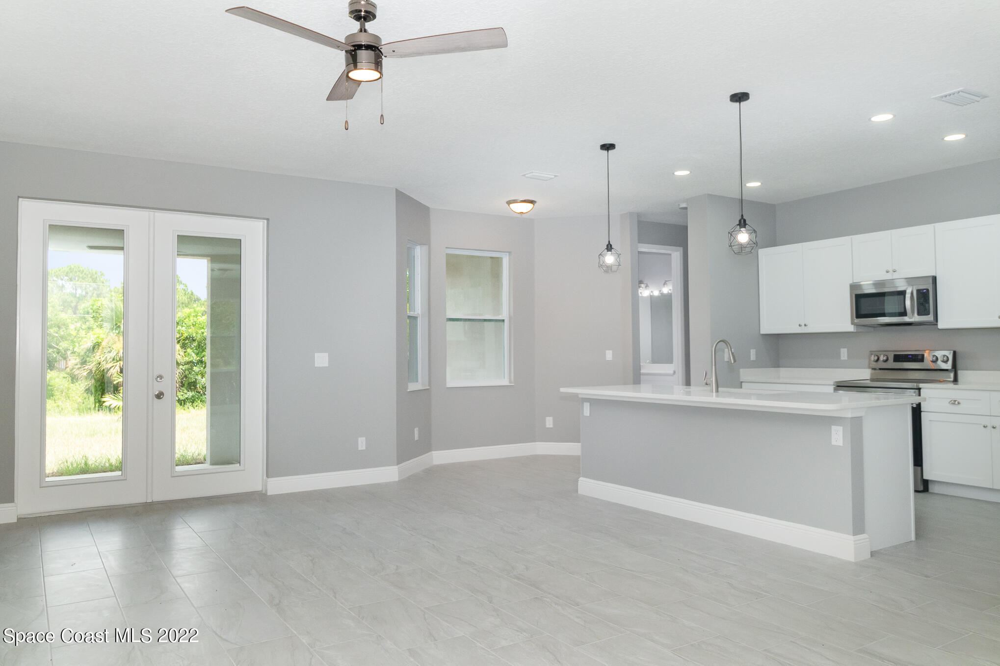 295 San Marino Road Southwest Palm Bay, FL 32908 - Photo 7 of 49 a view of kitchen with granite countertop a stove top oven a sink dishwasher a dining table and chairs with wooden floor