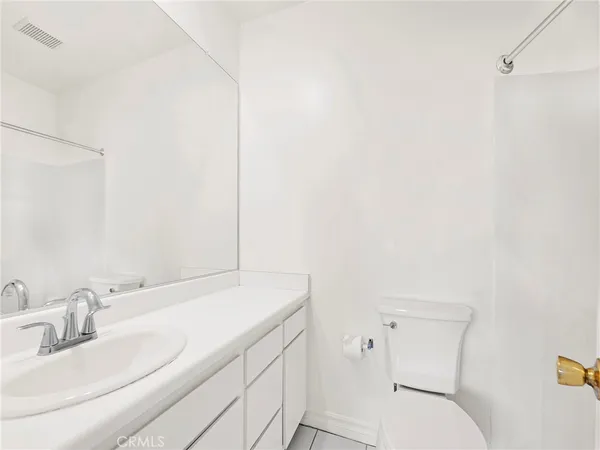 a bathroom with a sink mirror vanity and toilet