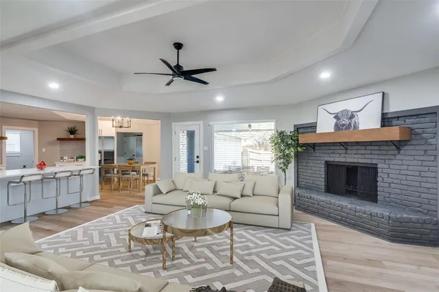 a living room with furniture a fireplace and a ceiling fan