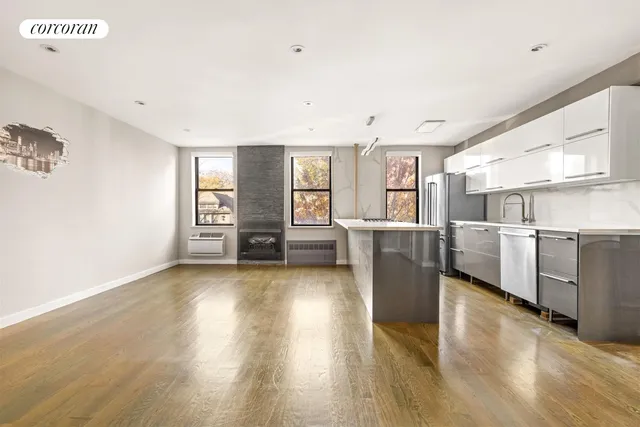 a view of a kitchen with furniture and wooden floor