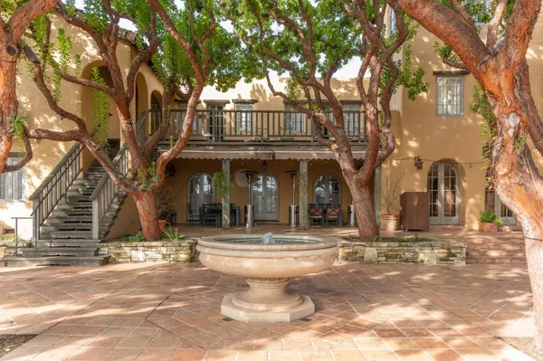 a view of a house next to a big yard with large trees