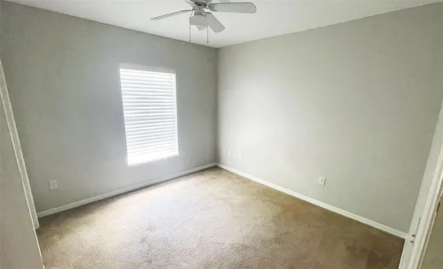 an empty room with a cabinet and a chandelier fan