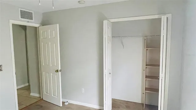 an empty room with a window and a fan