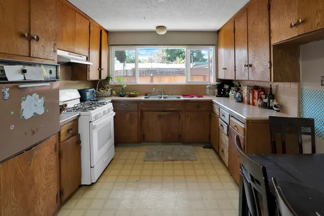 a kitchen with stainless steel appliances granite countertop a stove a sink dishwasher and a refrigerator