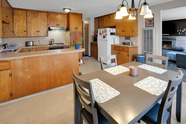 a view of a kitchen with refrigerator and wooden floor