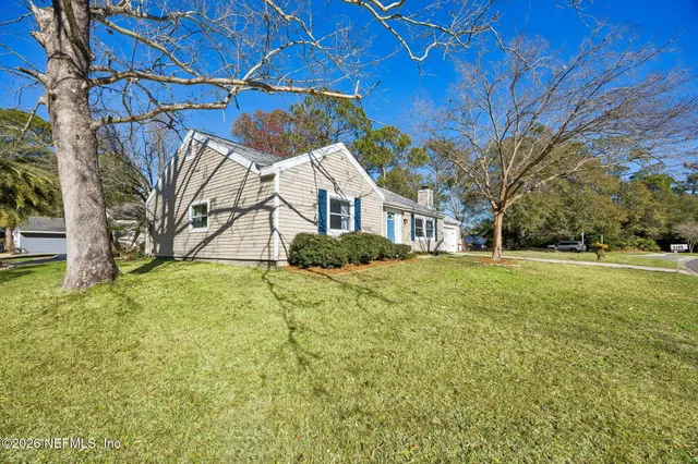 a view of house with yard and outdoor seating
