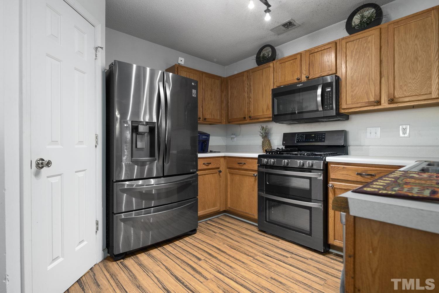 5904 Rivercliff Court Raleigh, NC 27610 - Photo 11 of 30 a kitchen with stainless steel appliances granite countertop a refrigerator stove and microwave