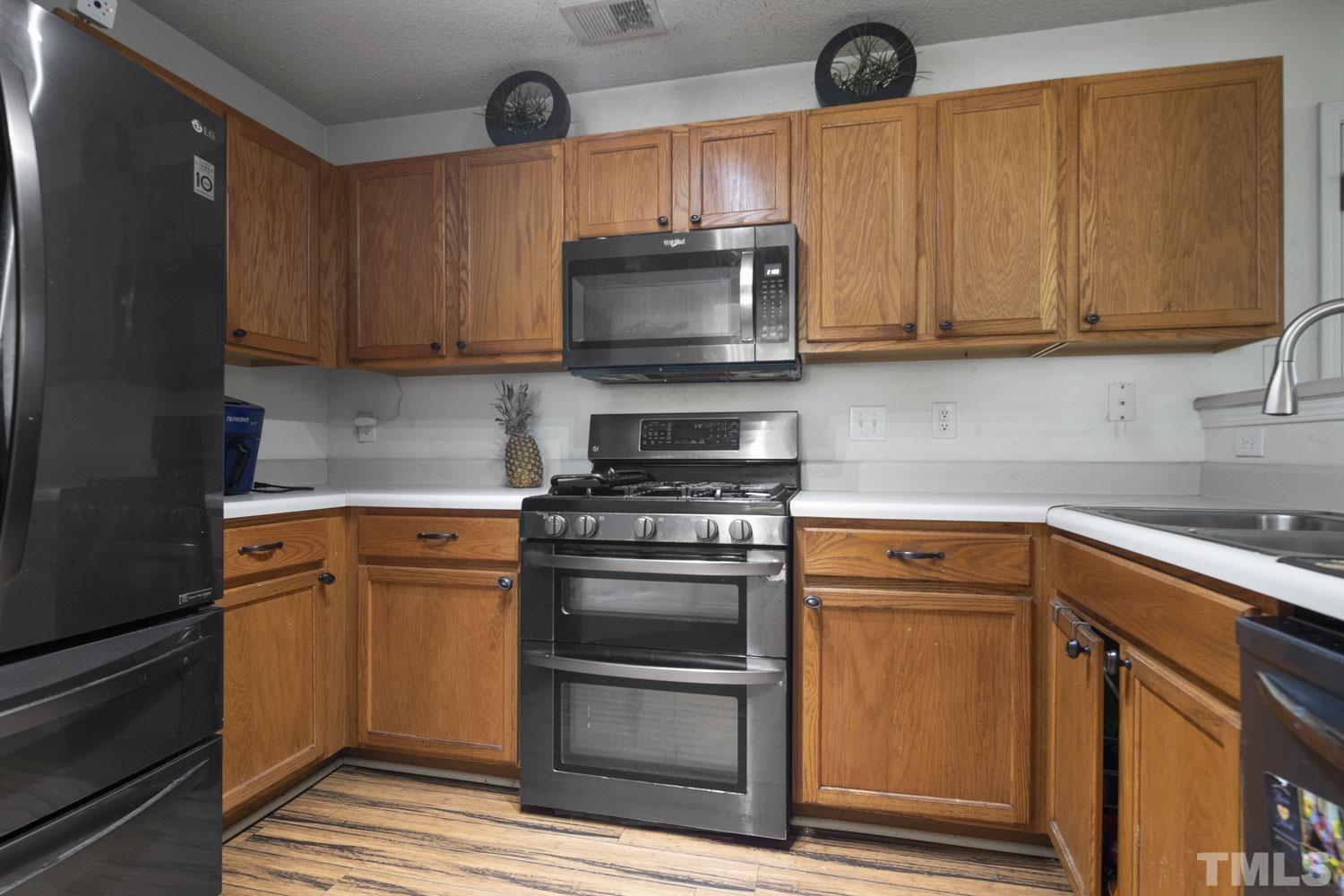 5904 Rivercliff Court Raleigh, NC 27610 - Photo 13 of 30 a kitchen with stainless steel appliances granite countertop a stove a sink and a microwave