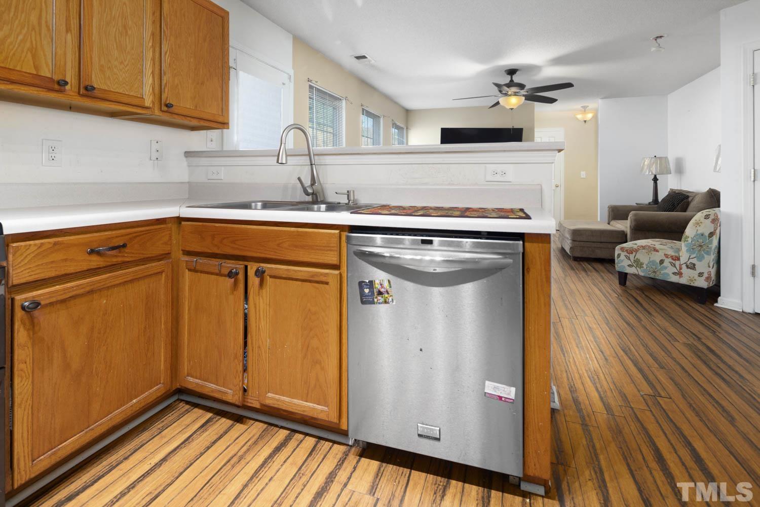 5904 Rivercliff Court Raleigh, NC 27610 - Photo 14 of 30 a kitchen with stainless steel appliances granite countertop a refrigerator a sink dishwasher and wooden cabinets with wooden floor