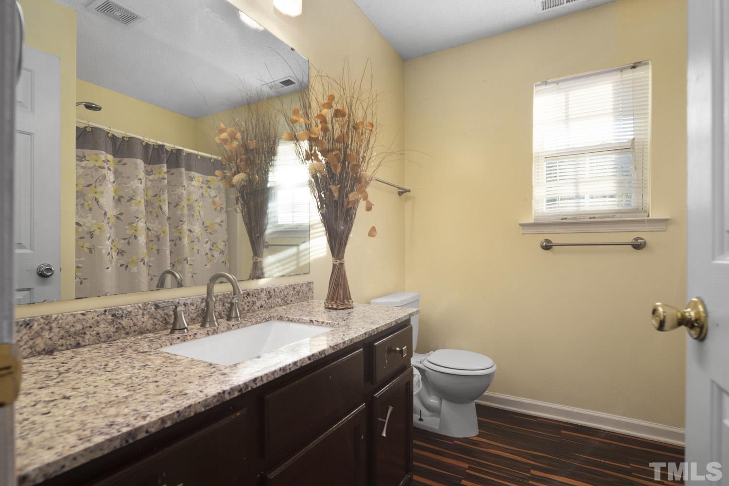 5904 Rivercliff Court Raleigh, NC 27610 - Photo 21 of 30 a bathroom with a granite countertop sink toilet and a mirror