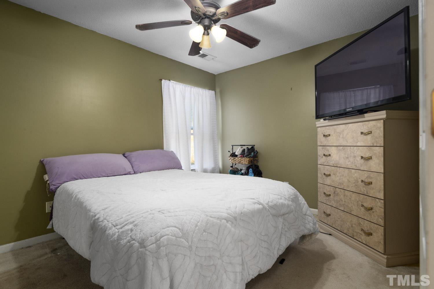 5904 Rivercliff Court Raleigh, NC 27610 - Photo 25 of 30 a bedroom with a bed and a ceiling fan