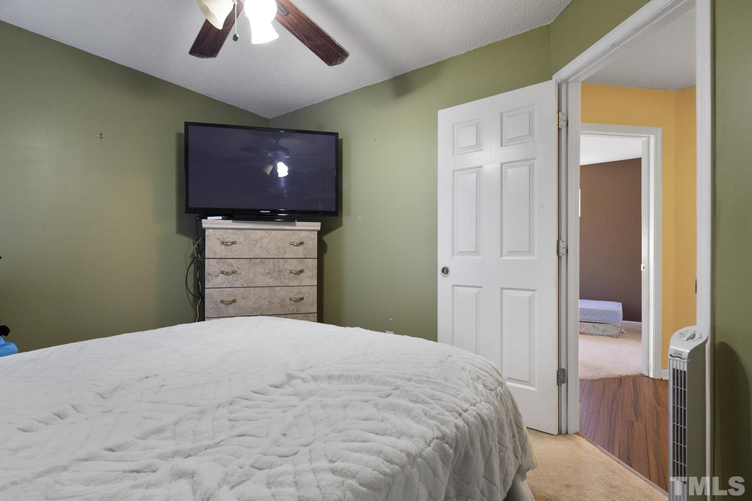 5904 Rivercliff Court Raleigh, NC 27610 - Photo 26 of 30 a bedroom with a bed and a flat screen tv