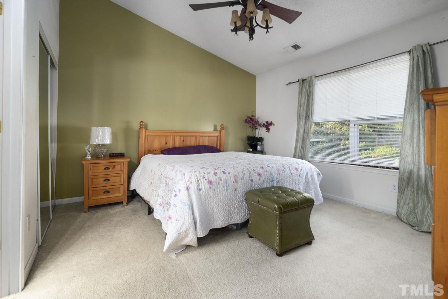 5904 Rivercliff Court Raleigh, NC 27610 - Photo 27 of 30 a bedroom with a bed a chandelier and a window
