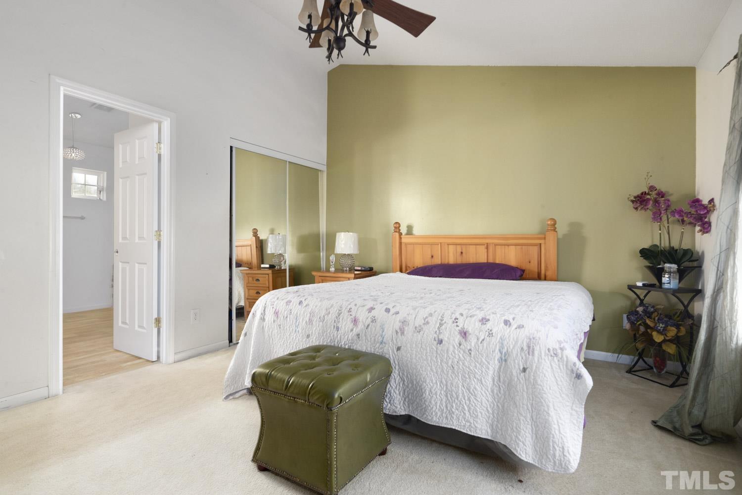 5904 Rivercliff Court Raleigh, NC 27610 - Photo 28 of 30 a bedroom with a bed and a chandelier