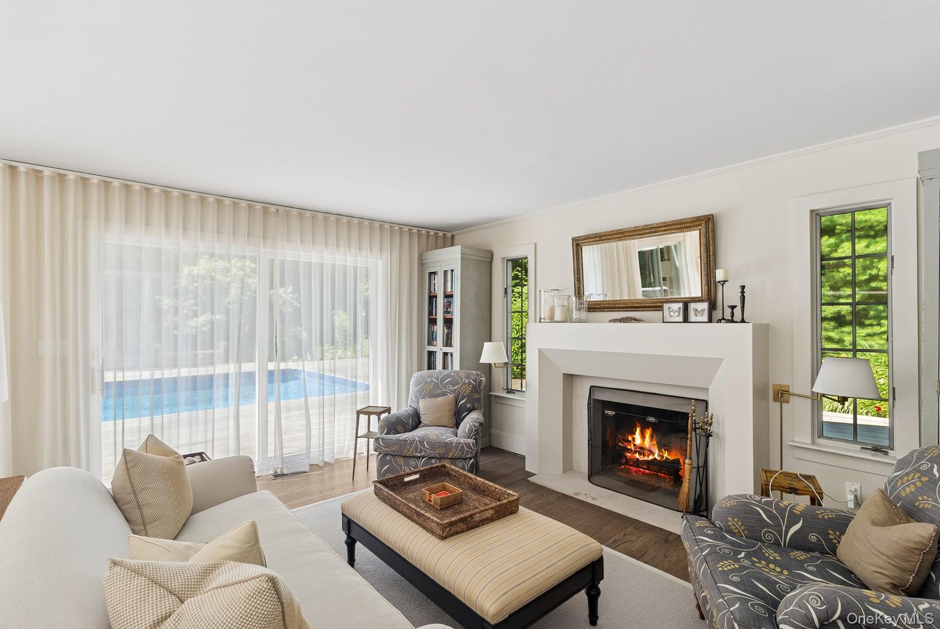 530 Hands Creek Road East Hampton, NY 11937 - Photo 13 of 47 Living area featuring wood finished floors, a fireplace with flush hearth, and ornamental molding