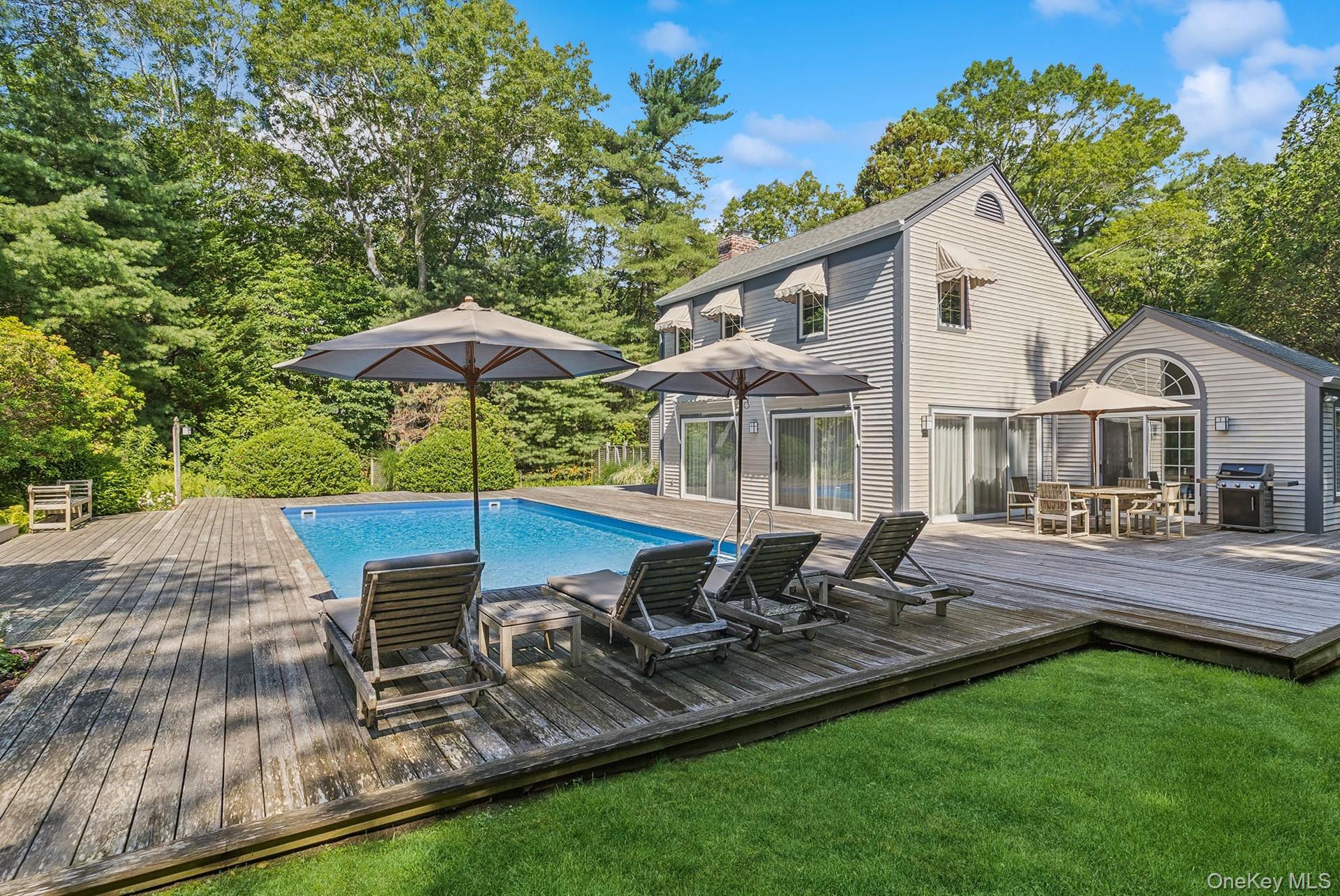 530 Hands Creek Road East Hampton, NY 11937 - Photo 35 of 47 Outdoor pool with a deck, grilling area, outdoor dining area, a lawn, and view of wooded area