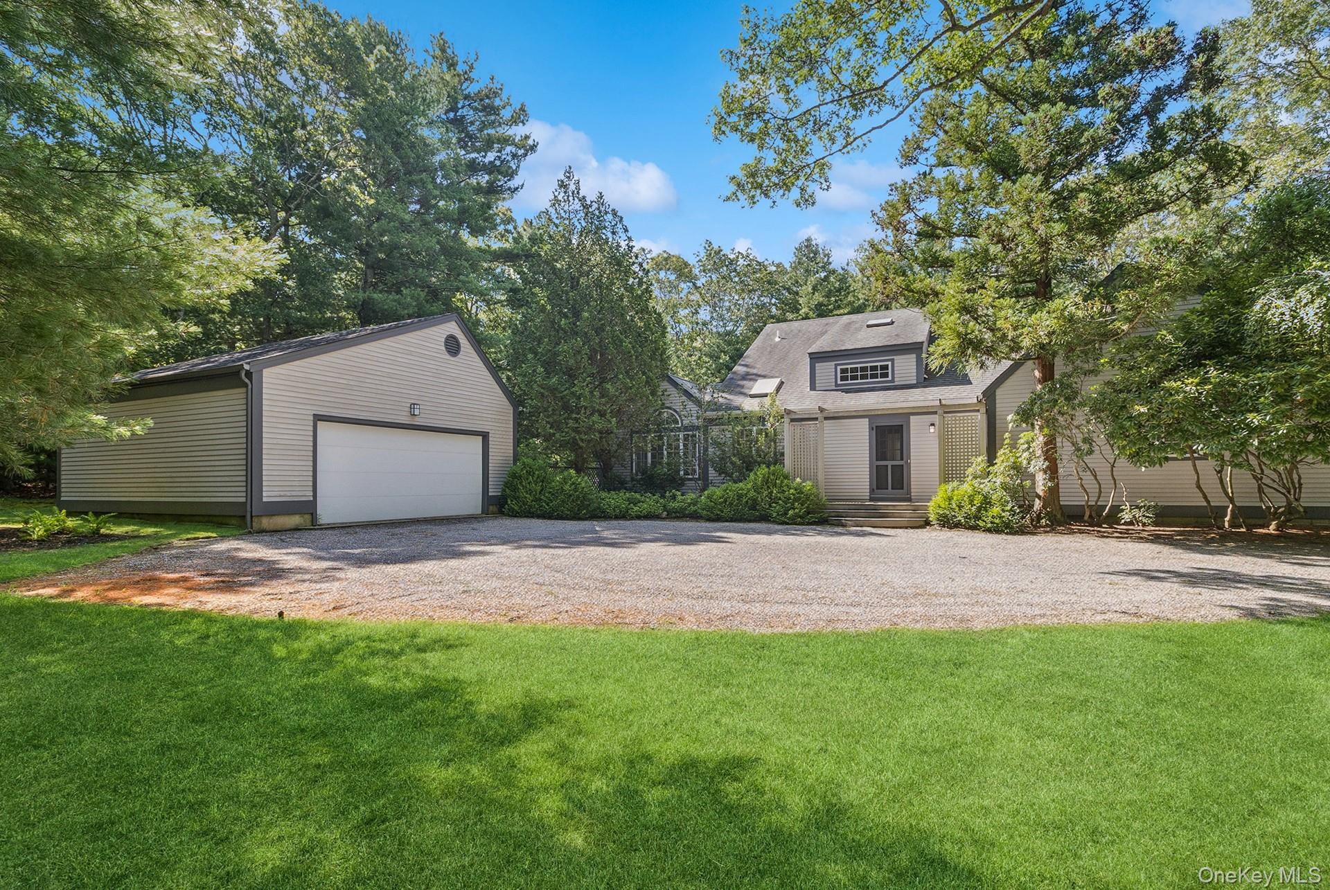 530 Hands Creek Road East Hampton, NY 11937 - Photo 9 of 47 View of green lawn with an outbuilding and a garage
