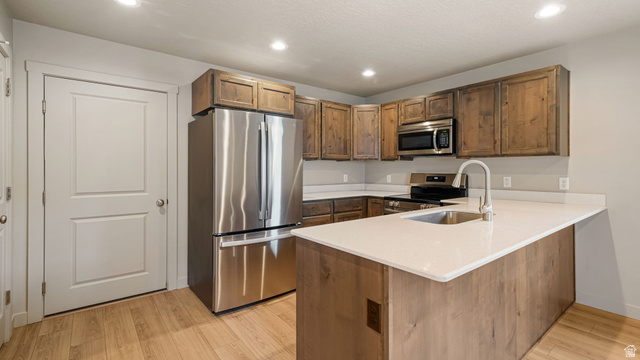 1223 East 1775 North Payson, UT 84651 - Photo 25 of 45 Kitchen featuring wood-finish flooring, white countertops, dark wood-tone cabinetry, and stainless steel appliances including a refrigerator, microwave, and range