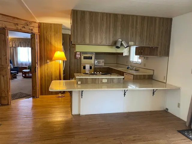 a kitchen with a sink cabinets and wooden floor