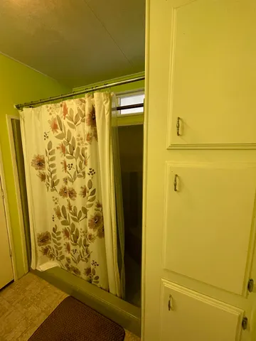 a bathroom with a shower and a door