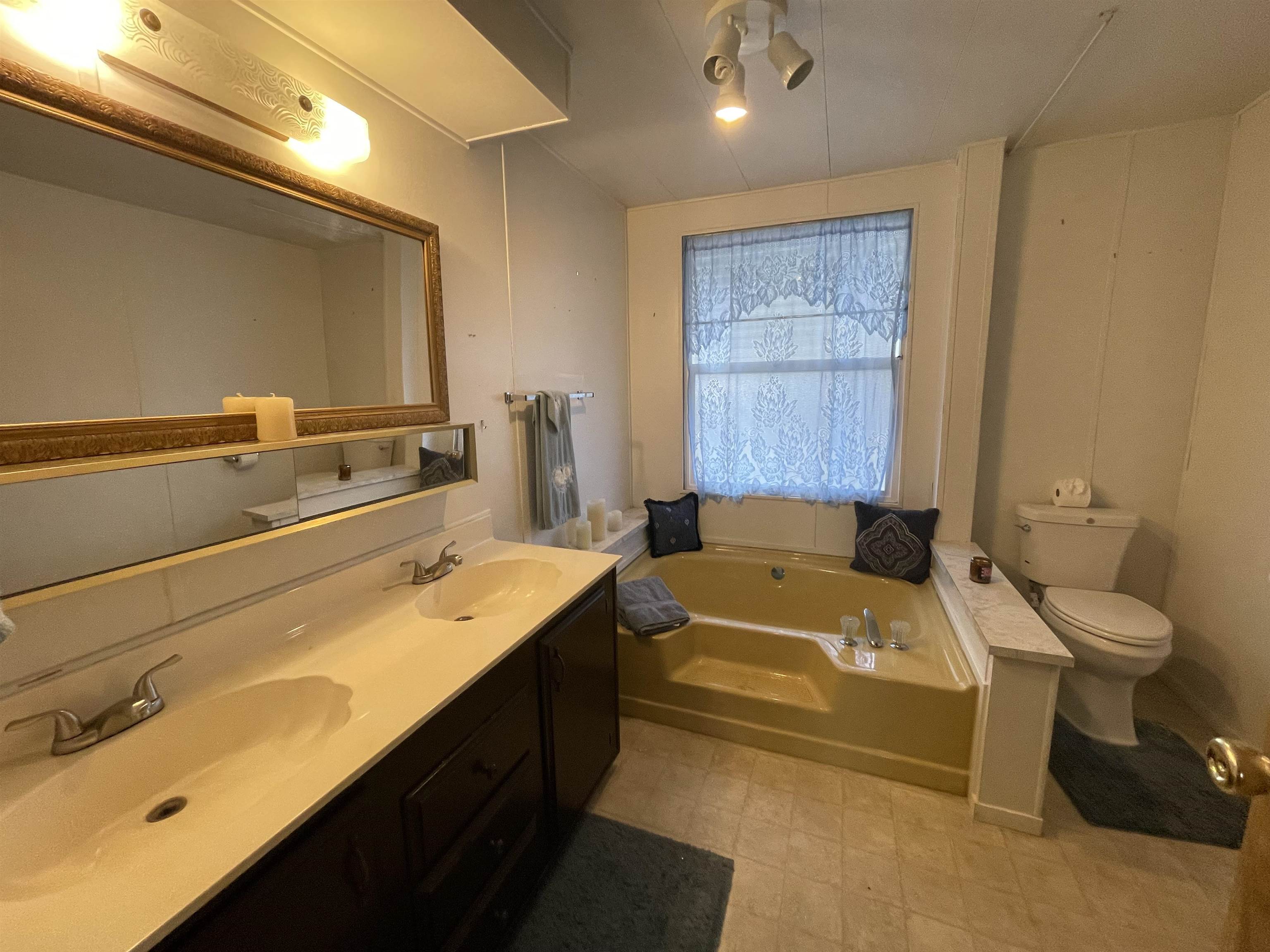 10956 Green Street, Unit 218 Columbia, CA 95310 - Photo 17 of 21 a bathroom with a tub sink toilet and mirror