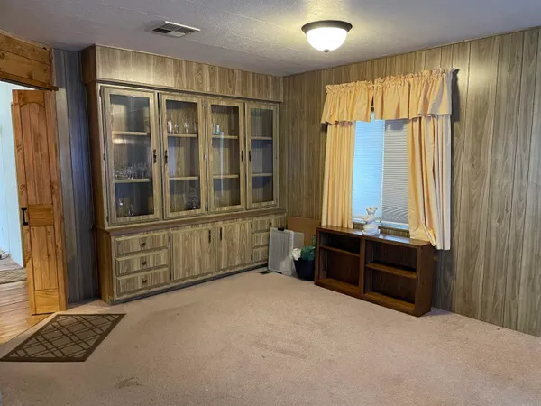 an empty room with windows and cabinet