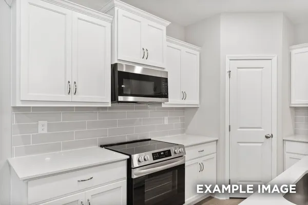 a kitchen with granite countertop white cabinets and stainless steel appliances