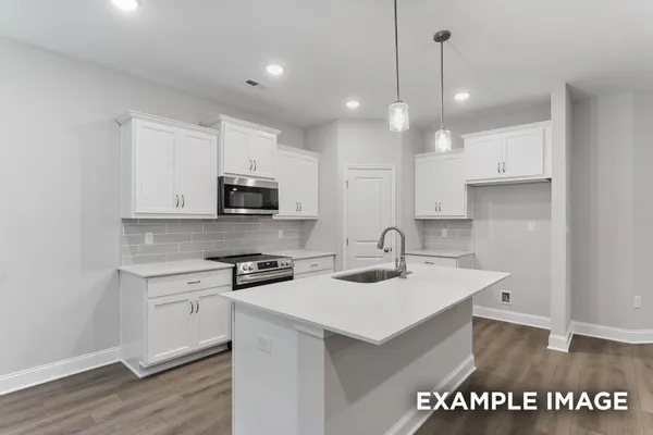 a kitchen with a sink a microwave and cabinets