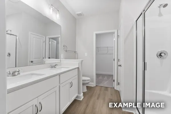 a spacious bathroom with a shower sink and a toilet