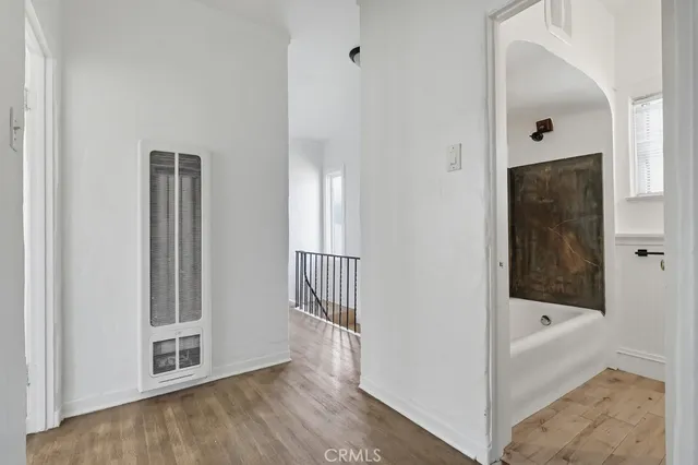 a very nice looking room with wooden floor and a bathroom