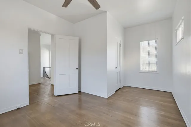 an empty room with wooden floor and window