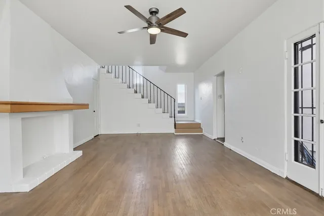 a view of room with stairs and wooden floor
