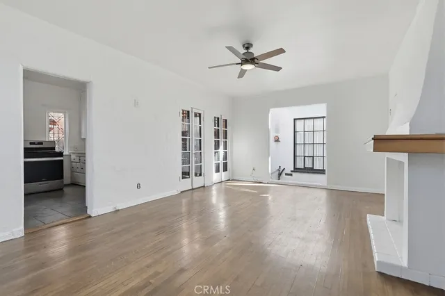 a view of an empty room with a window and wooden floor
