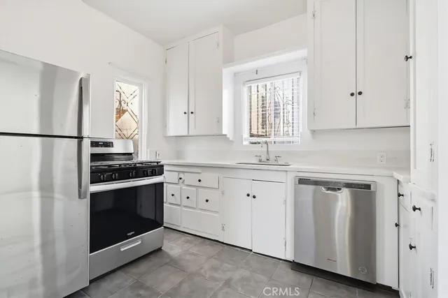 a kitchen with granite countertop white cabinets white stainless steel appliances and sink
