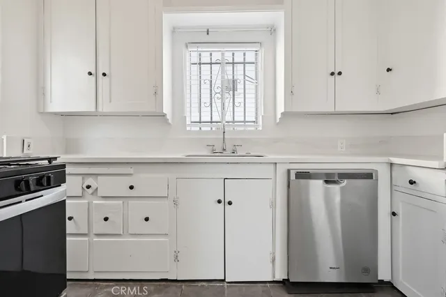 a kitchen with white cabinets and white appliances