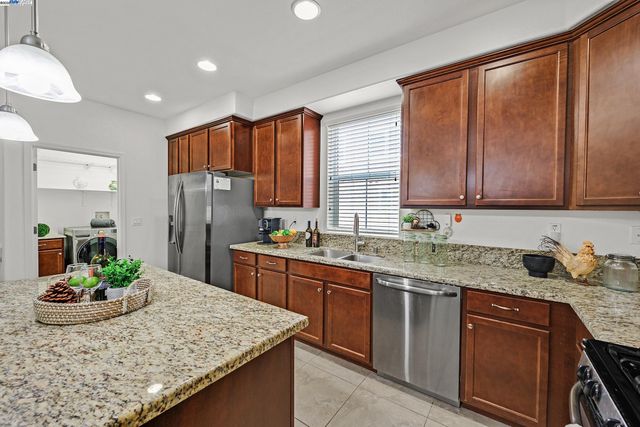 a kitchen with stainless steel appliances granite countertop sink stove and refrigerator