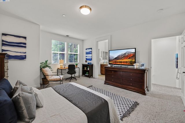 a bedroom with furniture and a flat screen tv