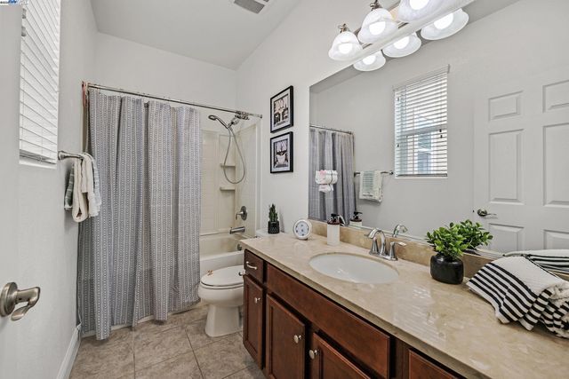 a bathroom with a granite countertop sink a toilet and shower