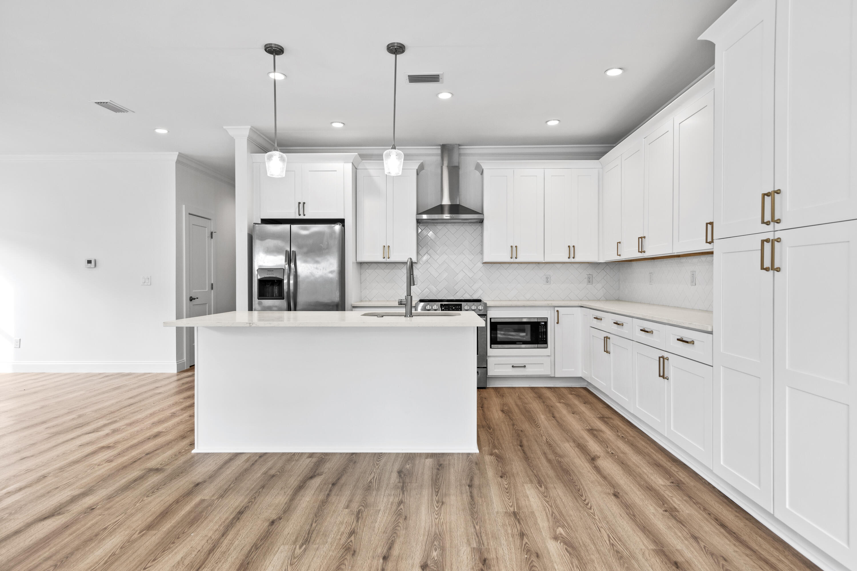 60 4th Street Santa Rosa Beach, FL 32459 - Photo 2 of 22 a large kitchen with stainless steel appliances a large counter top a stove a refrigerator and white cabinets