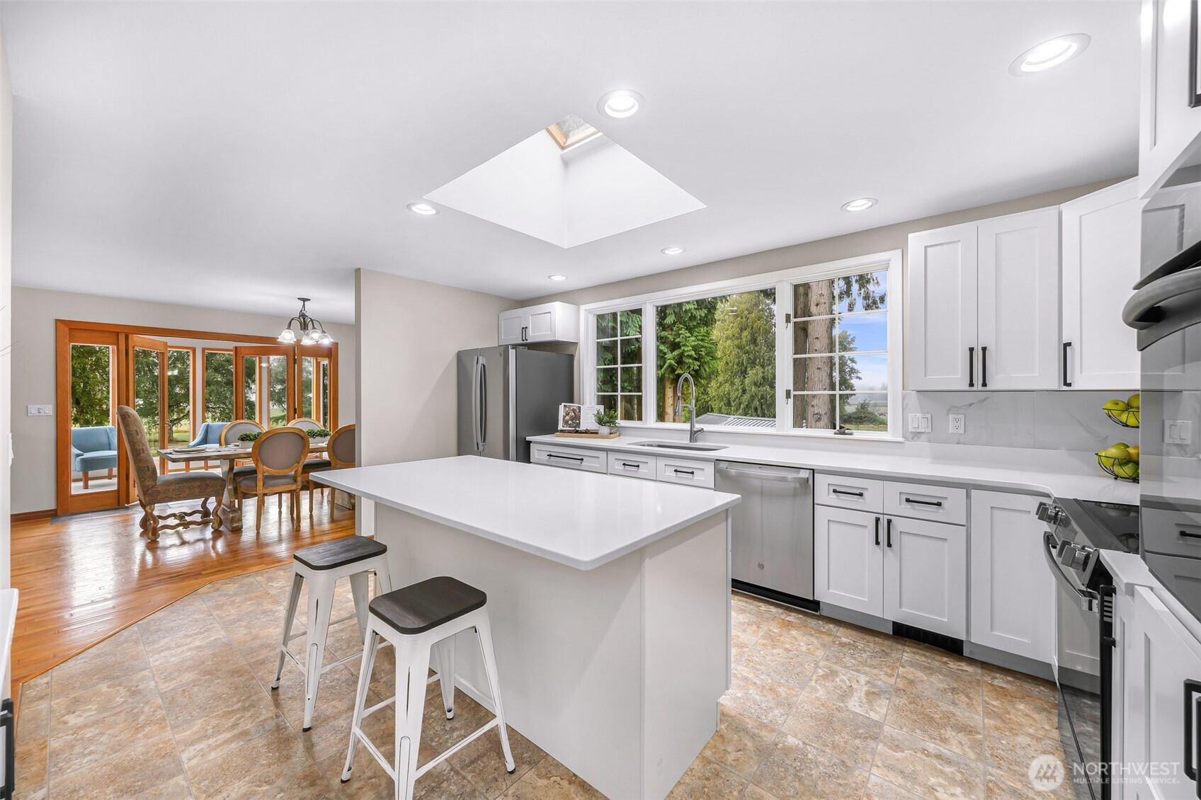 9067 Sunrise Road Custer, WA 98240 - Photo 9 of 40 a kitchen with a stove a sink a dining table and chairs