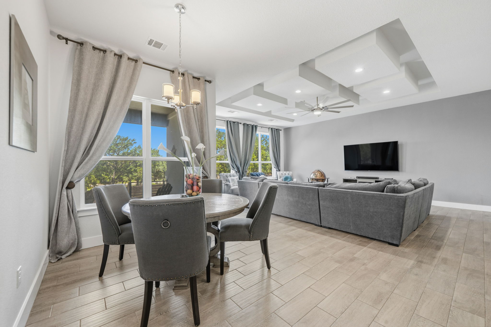 18605 Masters Cove Point Venture, TX 78645 - Photo 15 of 40 Open-concept living space featuring wood-finish flooring, recessed lighting, a modern ceiling fan, and large windows with outdoor scenery