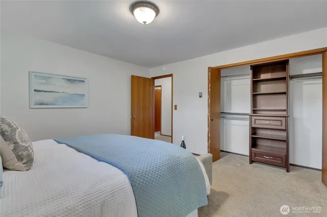 a bedroom with a bed and a refrigerator