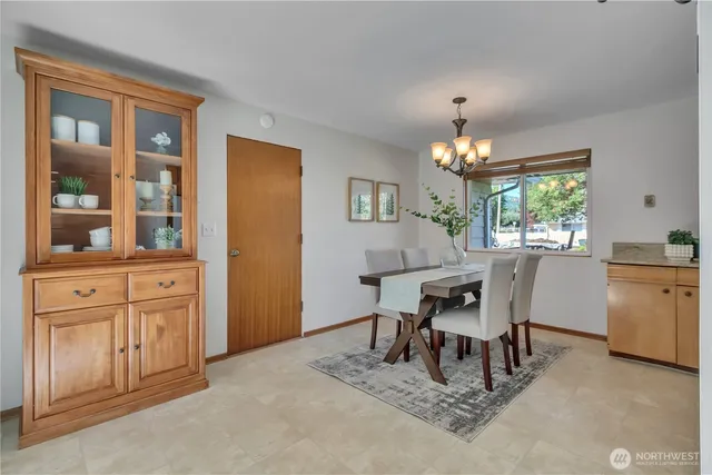 a dining room with furniture a chandelier and window